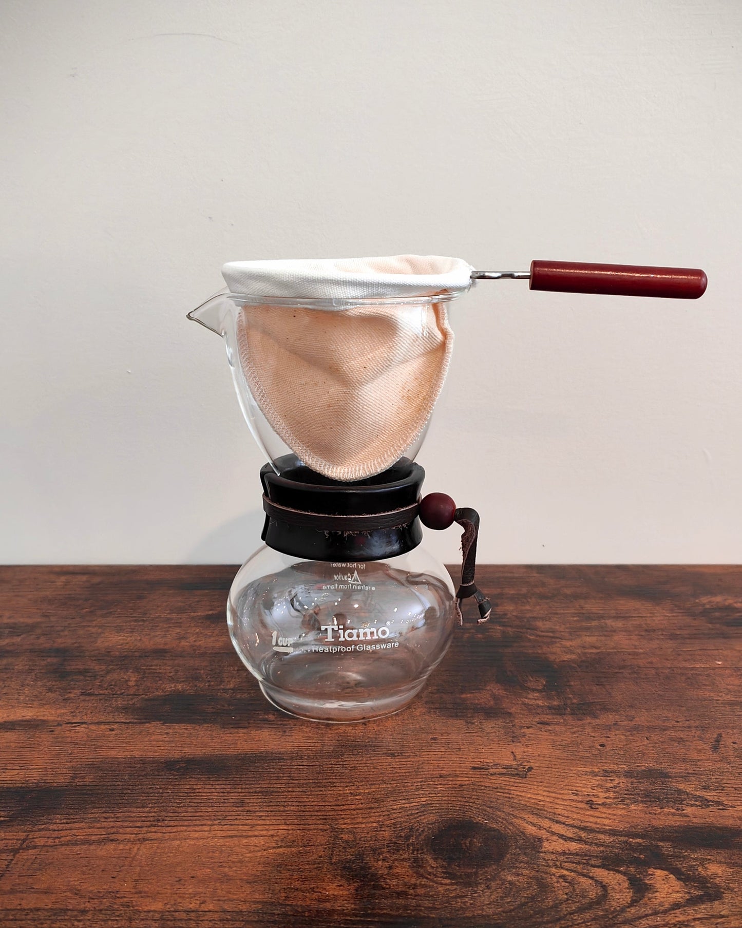 Glass coffee maker with a wooden handle on a wooden surface